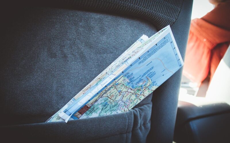 A folded map in a car seat pocket, perfect for planning a road trip.