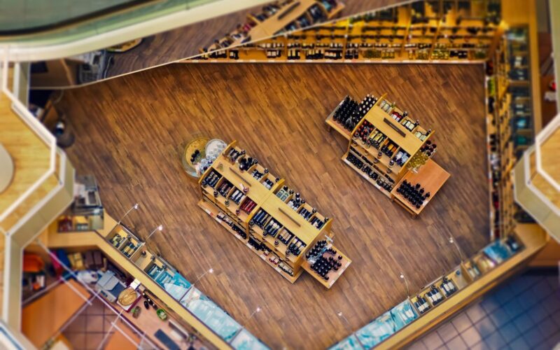 Explore the stylish interior of a contemporary liquor store with wooden shelves and a wide selection of beverages.