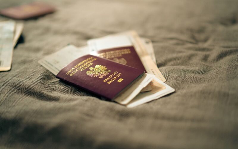 A close-up of a Polish passport and travel documents placed on a fabric surface, symbolizing travel and identity.