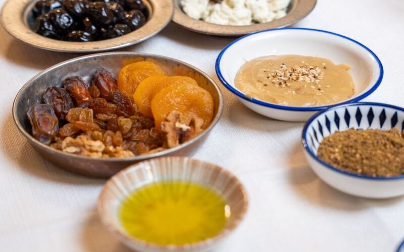 Delicious spread of Turkish breakfast featuring olives, dates, cheeses, and more on a traditional table setting.