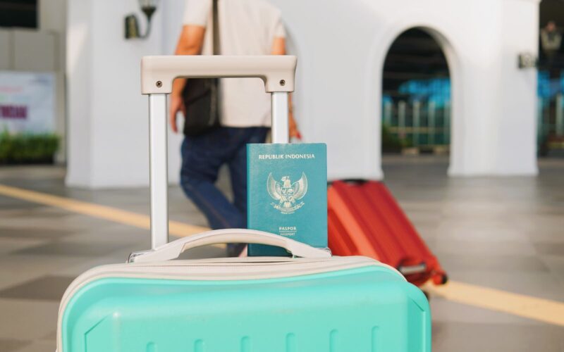 Traveler arrives at Yogyakarta airport, Indonesia with luggage and Indonesian passport in focus.
