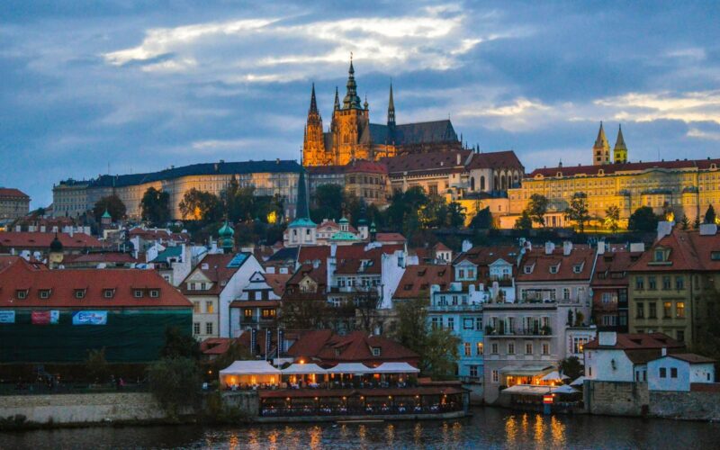 Capture the enchanting view of Prague Castle at twilight overlooking the historic cityscape.
