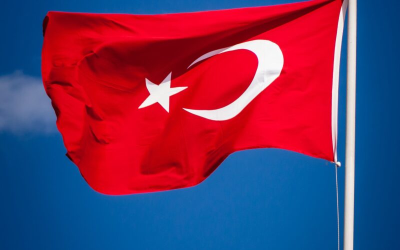 Açık mavi gökyüzü altında dalgalanan Türk bayrağı