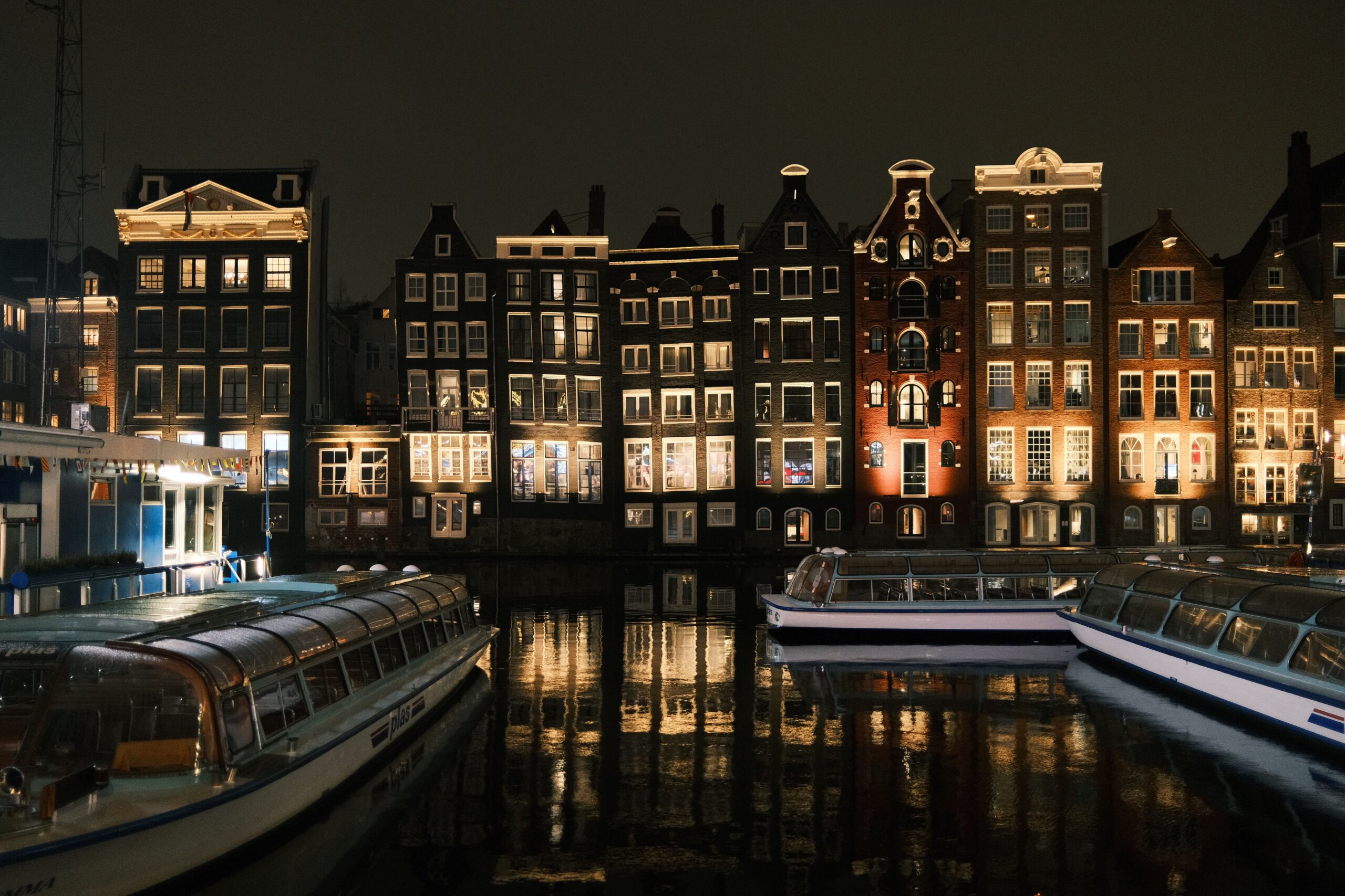 Amsterdam kanalları ve tarihi binalar gece ışıkları altında