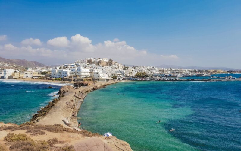 Captivating coastal view of Naxos Town with bright blue waters under a clear summer sky.
