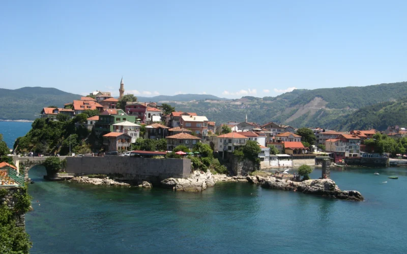 Amasra’nın iki koyu, kıyıdaki tarihî yapıları ve yeşil tepeleri gösteren liman manzarası