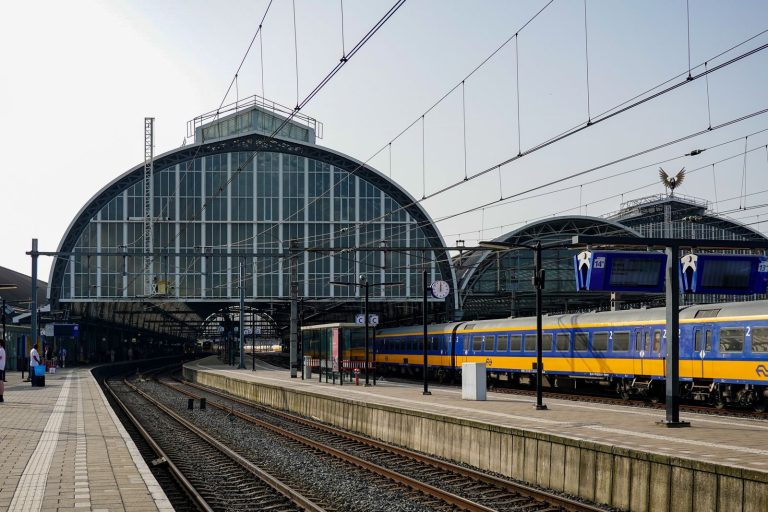 Amsterdam Centraal istasyonunun cam çatısı altındaki yolcu treni