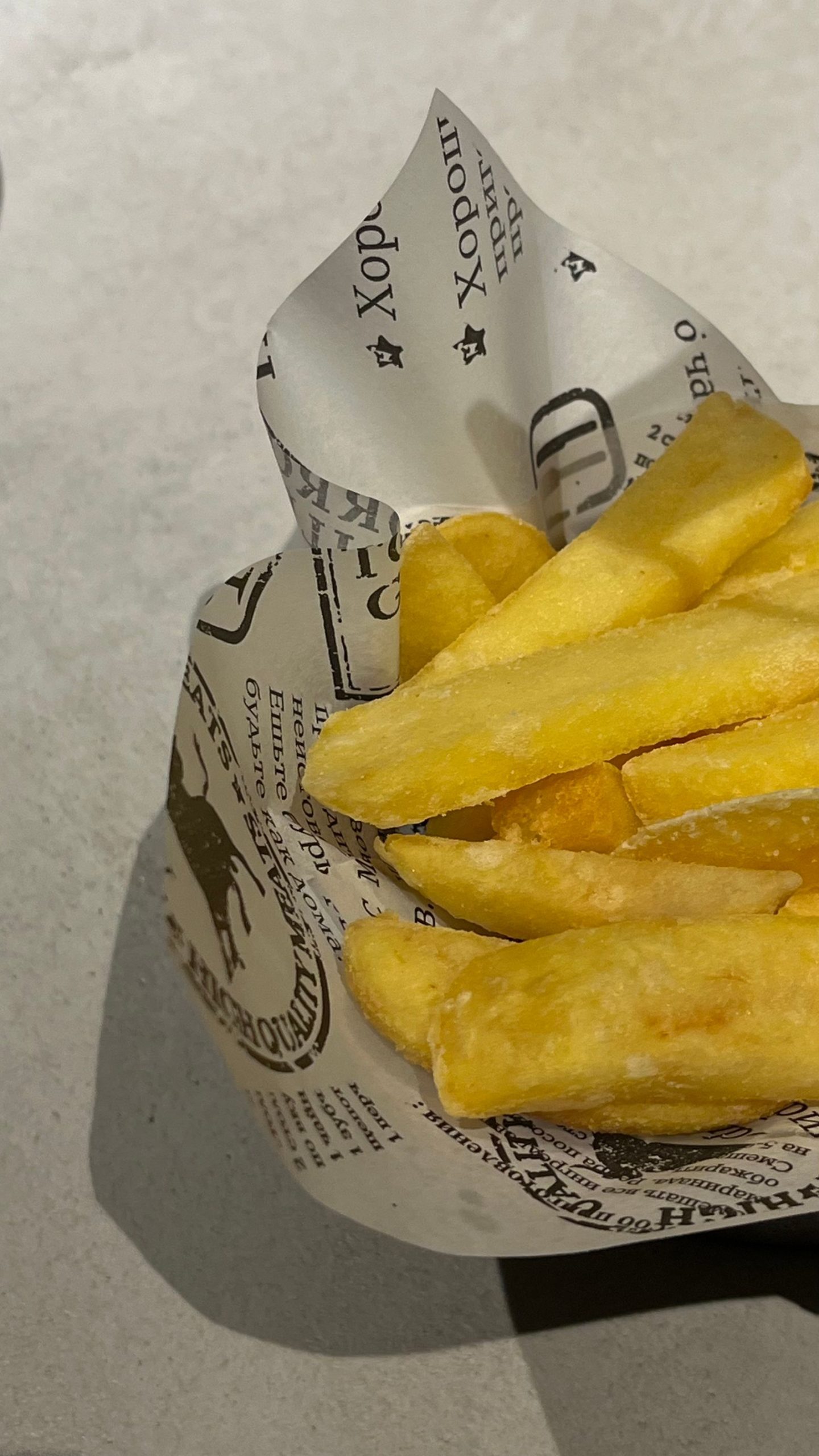 Kâğıt külah içinde altın renkli patates kızartmaları