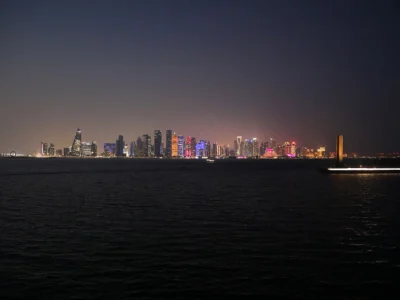 Doha Körfezi kıyısında gökdelenlerin aydınlattığı gece silüeti