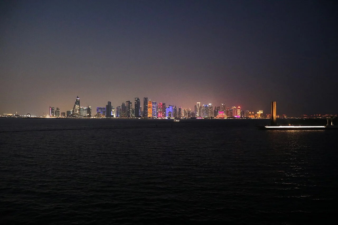 Doha Körfezi kıyısında gökdelenlerin aydınlattığı gece silüeti