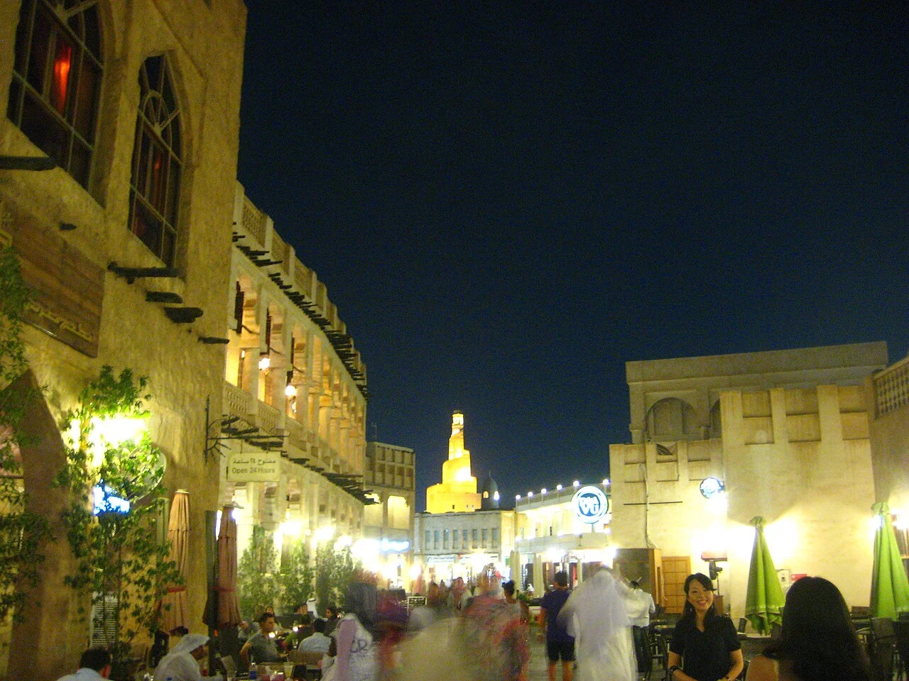Doha’daki Souq Waqif çarşısında akşam saatlerinde aydınlatılmış geleneksel cepheler ve ziyaretçiler