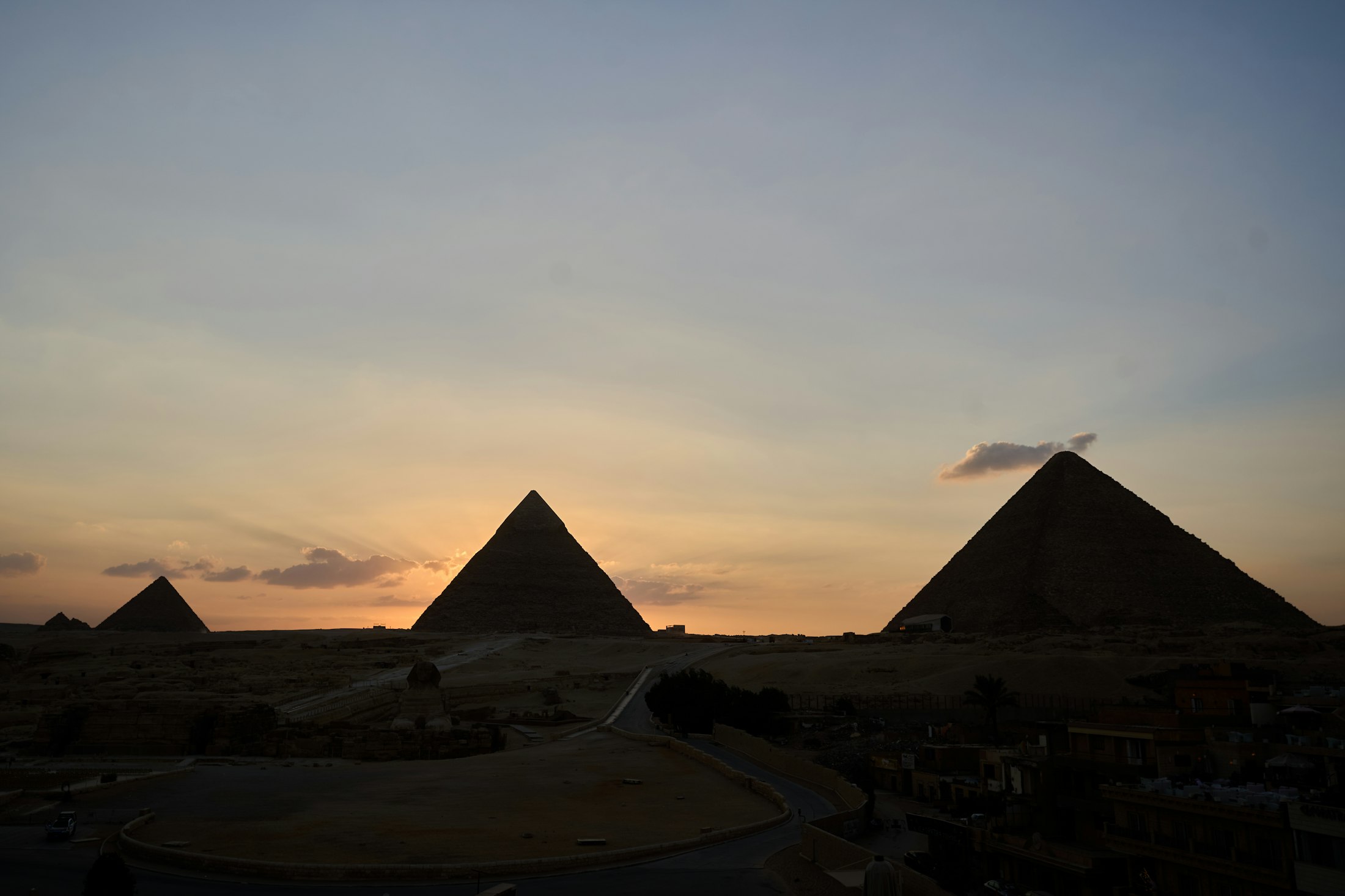 Giza’daki üç piramit ve Büyük Sfenks çevresinde gün batımına dönen ışık
