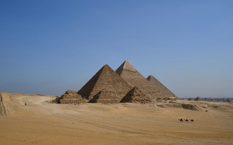 Giza Platosu’nda Khufu, Khafre ve Menkaure piramitlerini birlikte gösteren çöl manzarası