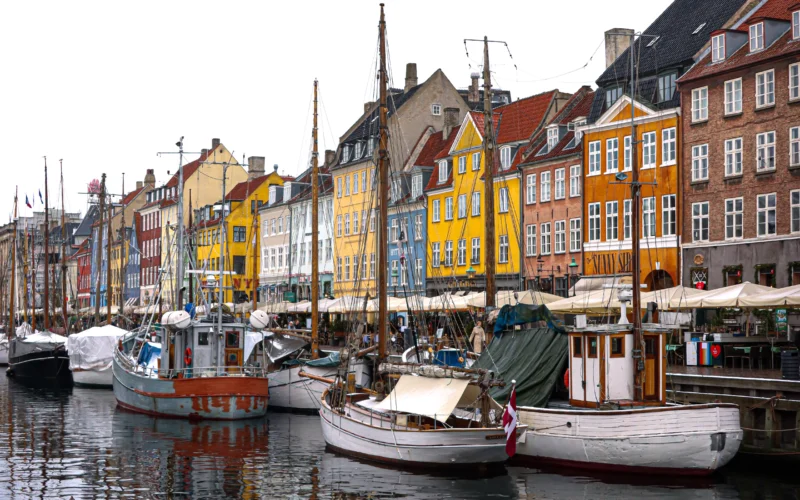 Kopenhag Nyhavn kanalında renkli tarihî evler ve kıyıya bağlı tekneler