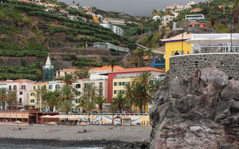 Madeira'daki Funchal kentinin yamaçlara yayılan renkli binaları ve kıyı şeridi