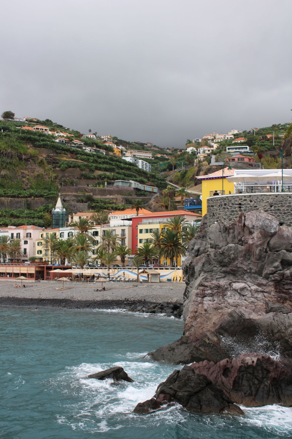Madeira'daki Funchal kentinin yamaçlara yayılan renkli binaları ve kıyı şeridi
