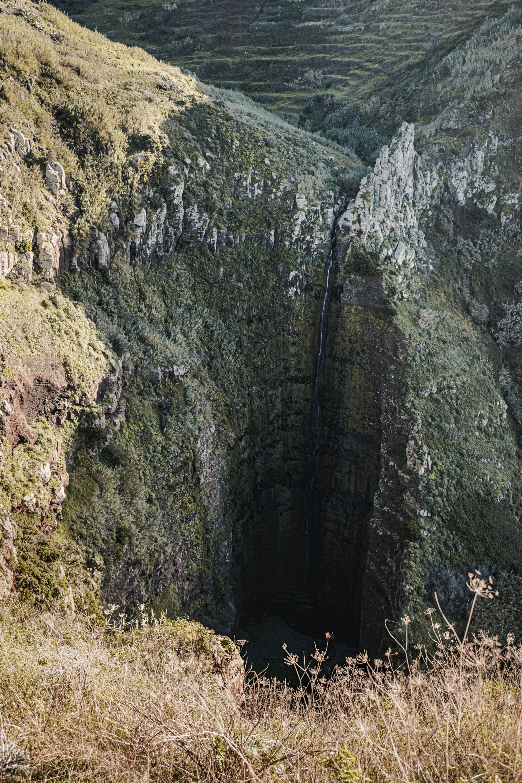 Madeira’nın yeşil yamaçları arasında derin bir vadiye dökülen şelale