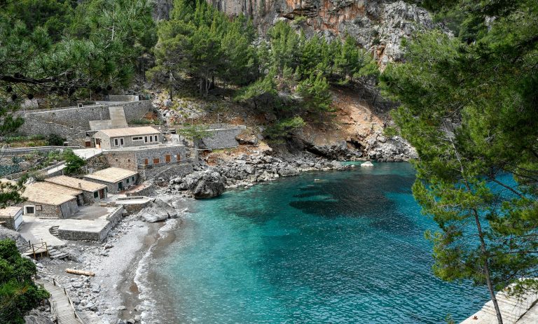 Mallorca’daki Sa Calobra koyunda kayalık kıyılar, beyaz evler ve turkuaz deniz