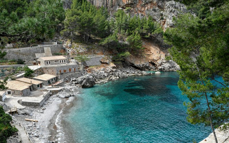 Mallorca’daki Sa Calobra koyunda kayalık kıyılar, beyaz evler ve turkuaz deniz