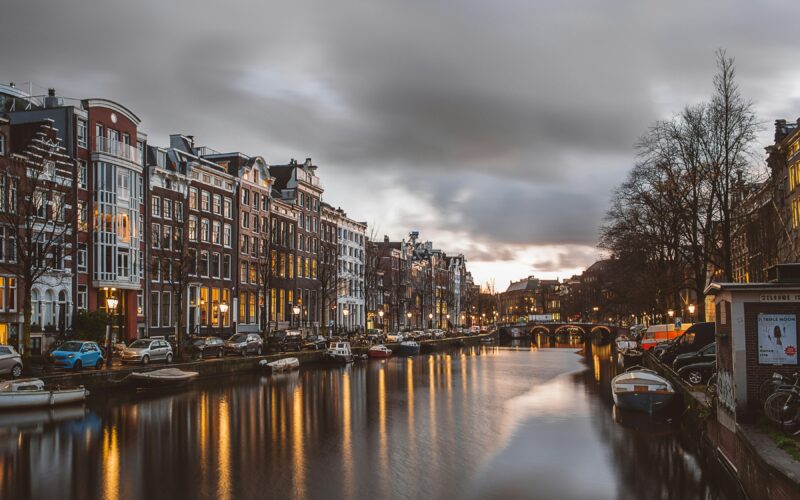 Amsterdam kanalı ve ışıklı şehir manzarası