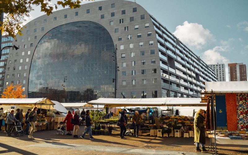 Rotterdam Markthal çevresinde açık hava tezgâhları ve modern kent mimarisi